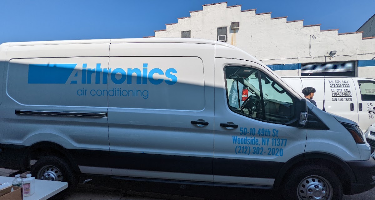 Rear window vinyl lettering and QR code decal on a white service van in New York